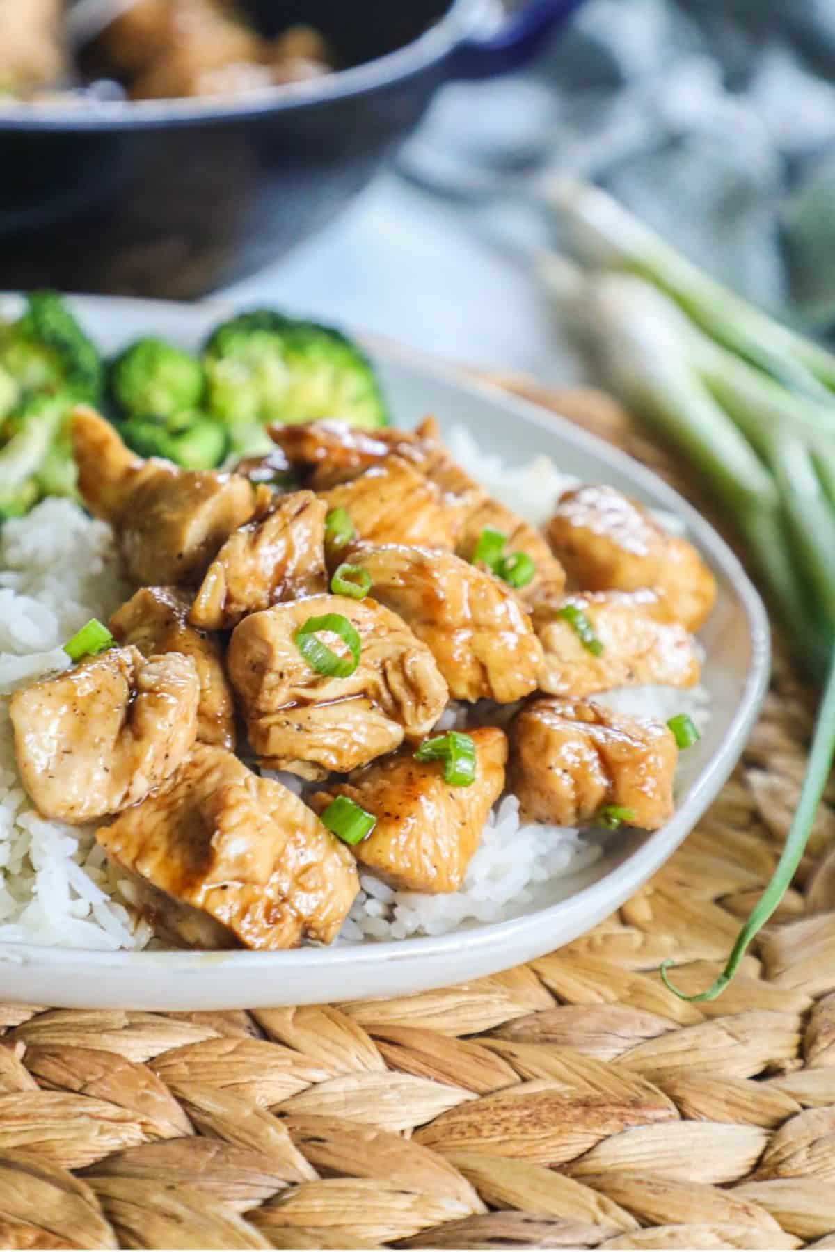 teriyaki chicken bites on a plate of white rice and broccoli