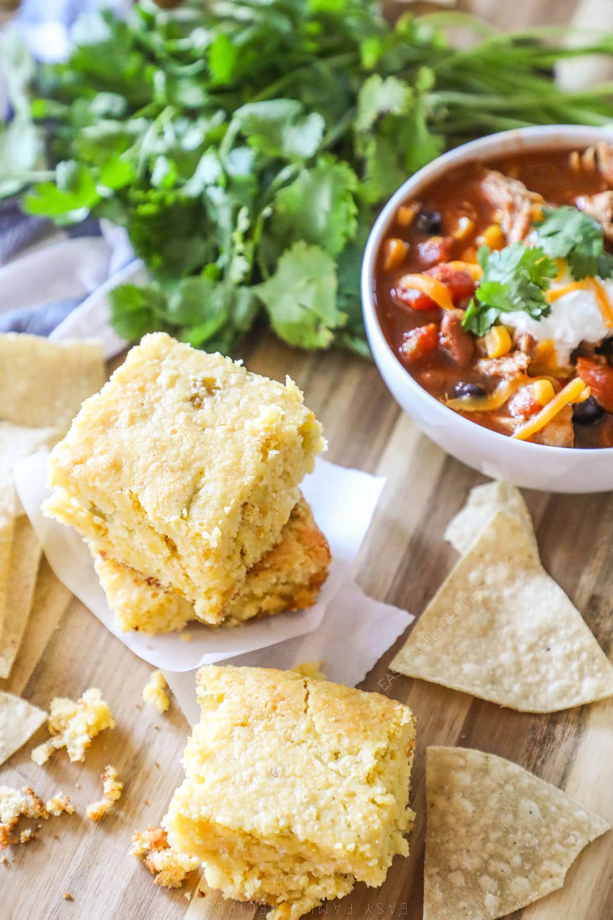 Sliced cornbread next to a bowl of chili