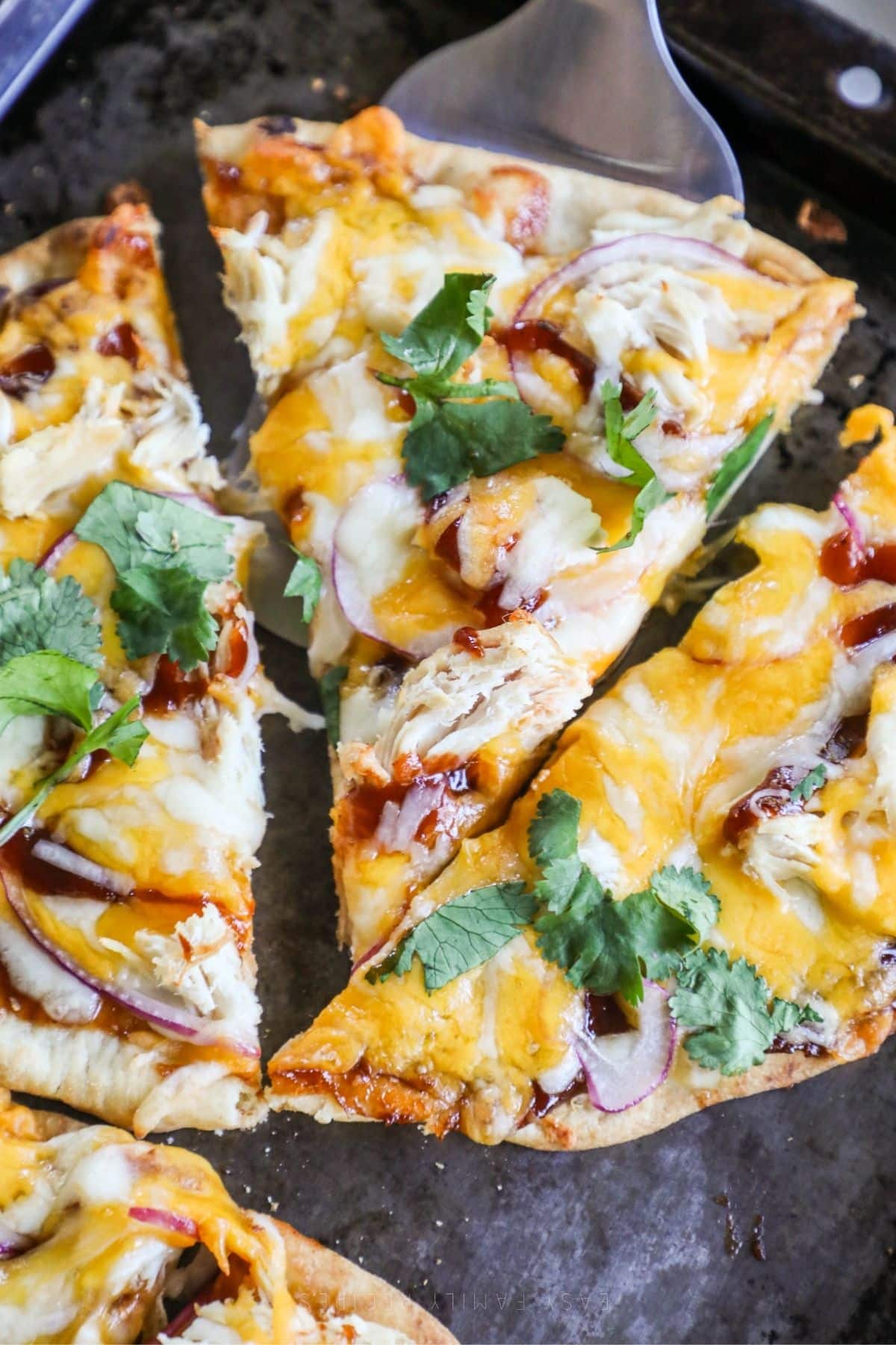 bbq chicken flatbread up into slices in a baking sheet
