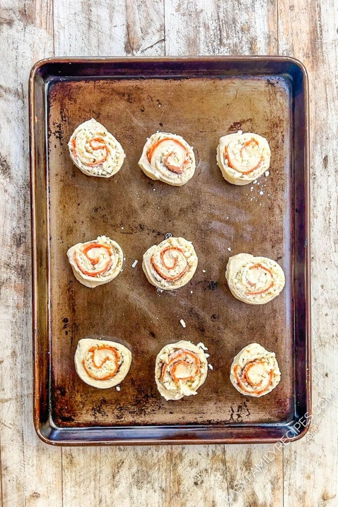 unbaked pizza rolls on a baking sheet.