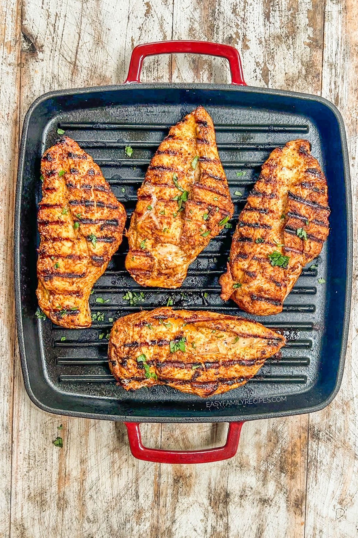 above image of four pieces of grilled chicken breast on a grill. 