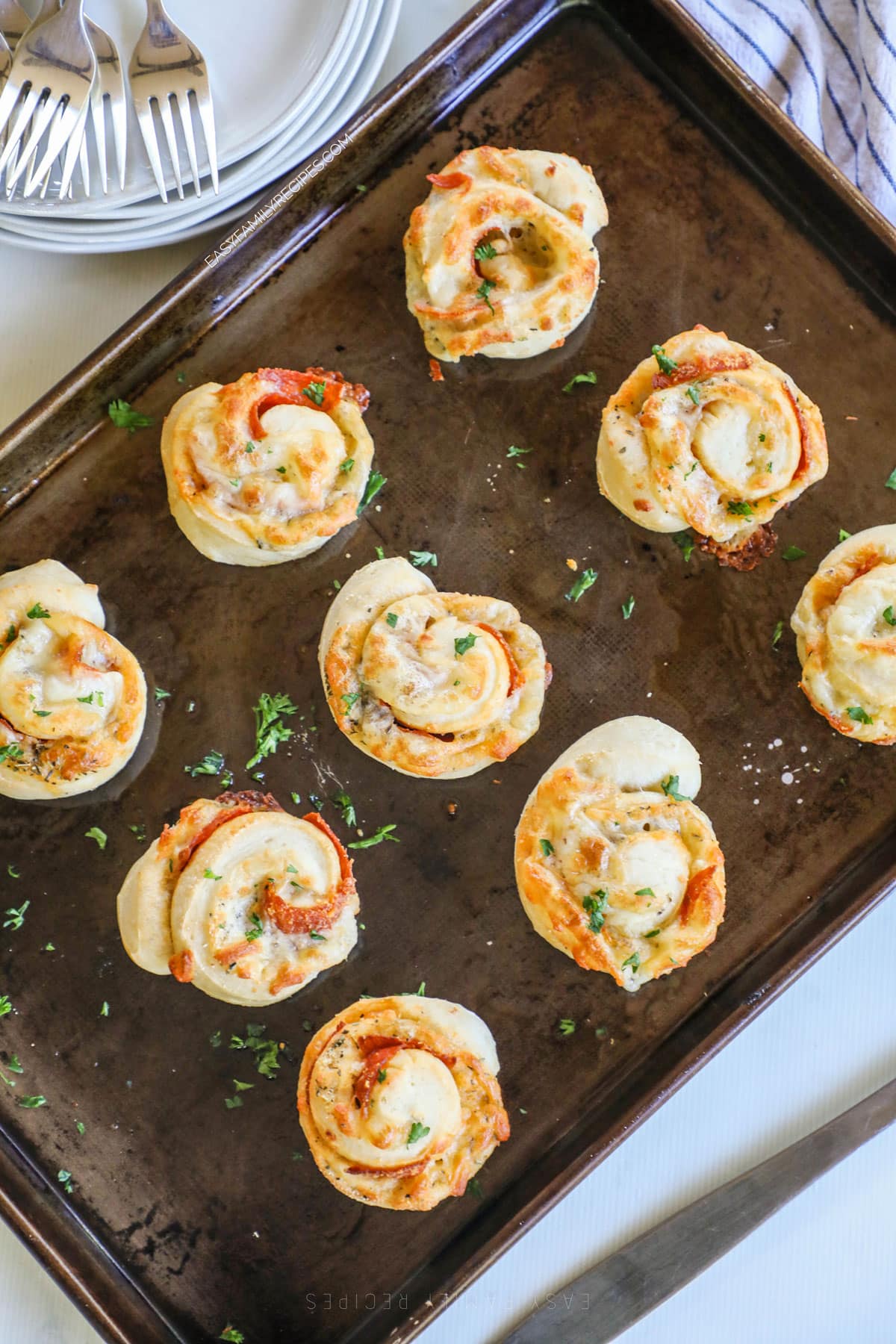 above image of homemade pepperoni pizza rolls on a baking sheet.