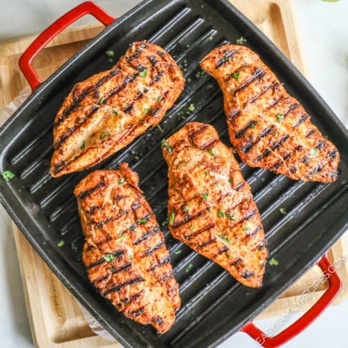 above image of four chicken breasts on a grill.