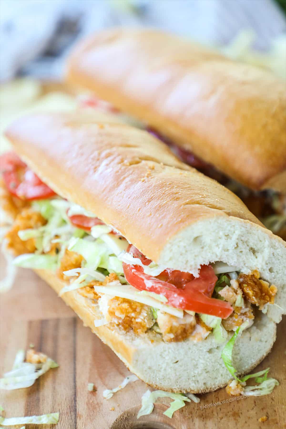 finished image of a sub - chicken tenders, tomatoes, and lettuce layered on French bread 