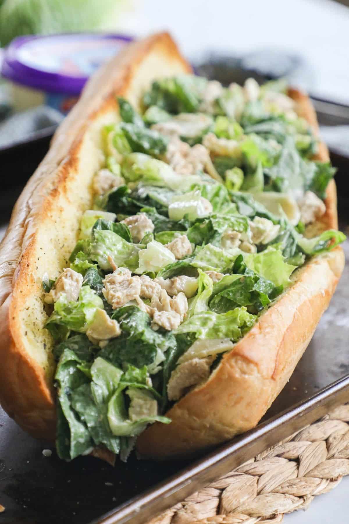 Garlic Bread Chicken Caesar - a bed of caesar salad in between a baguette