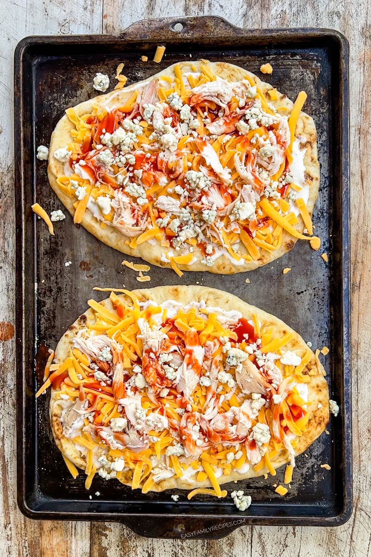 buffalo chicken flatbread on a baking sheet