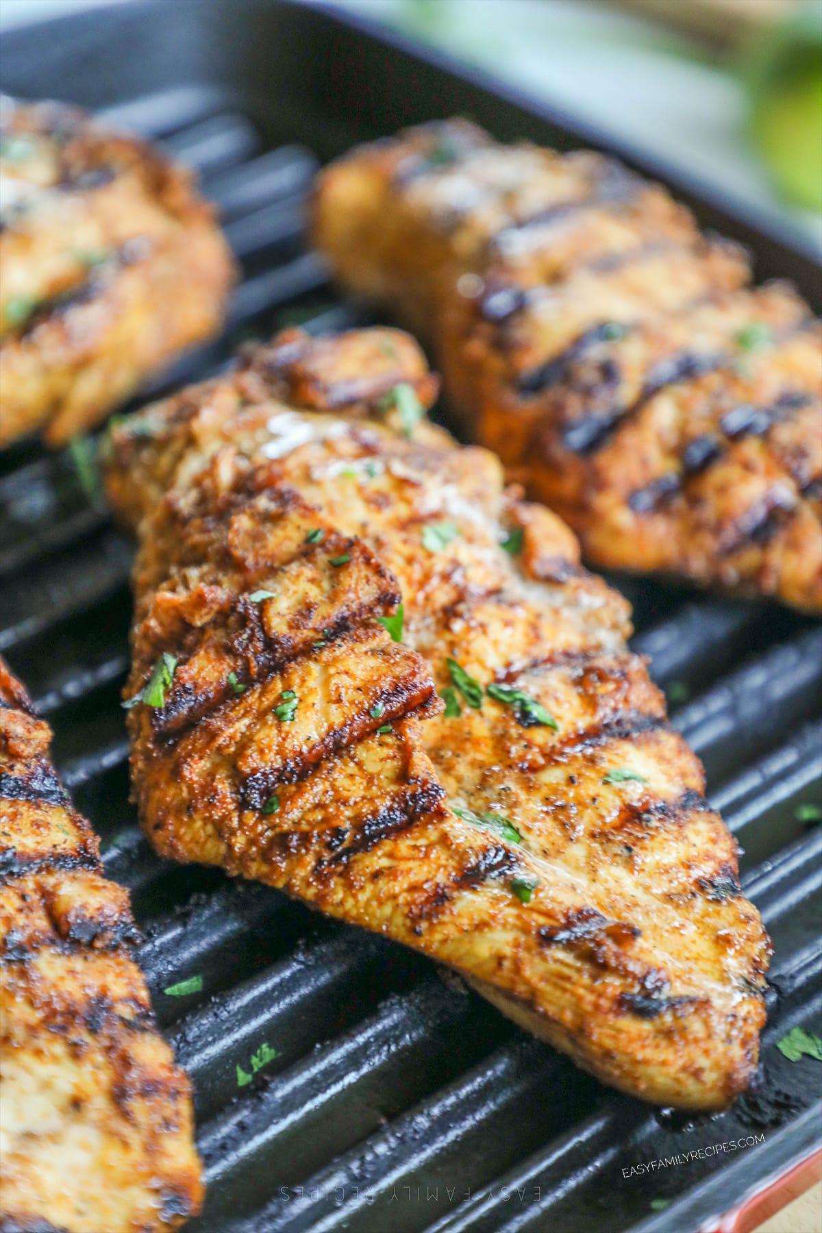 A close up of grilled southwest chicken being cooked, with herbs on top.