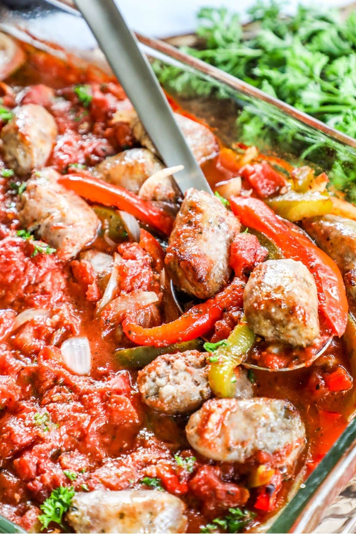 baked italian sausage and peppers casserole; spoon scooping out a spoonful
