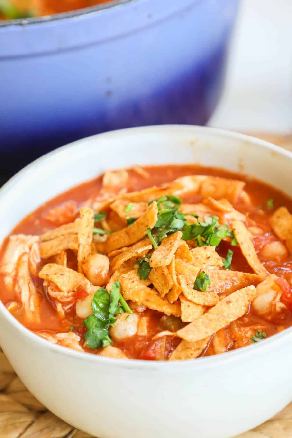 bowl of soutwest chicken soup topped with tortilla strips and cilantro