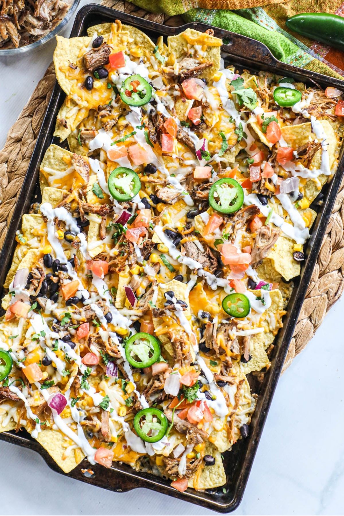 loaded carnitas nachos on a sheet pan