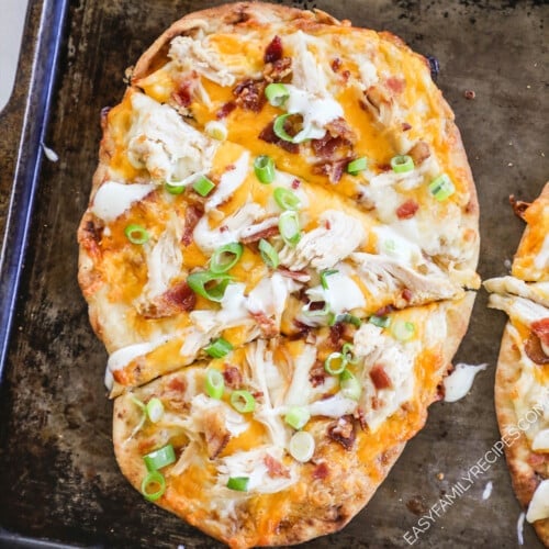 Chicken bacon ranch flatbread is sliced on a metal pan, ready to eat.