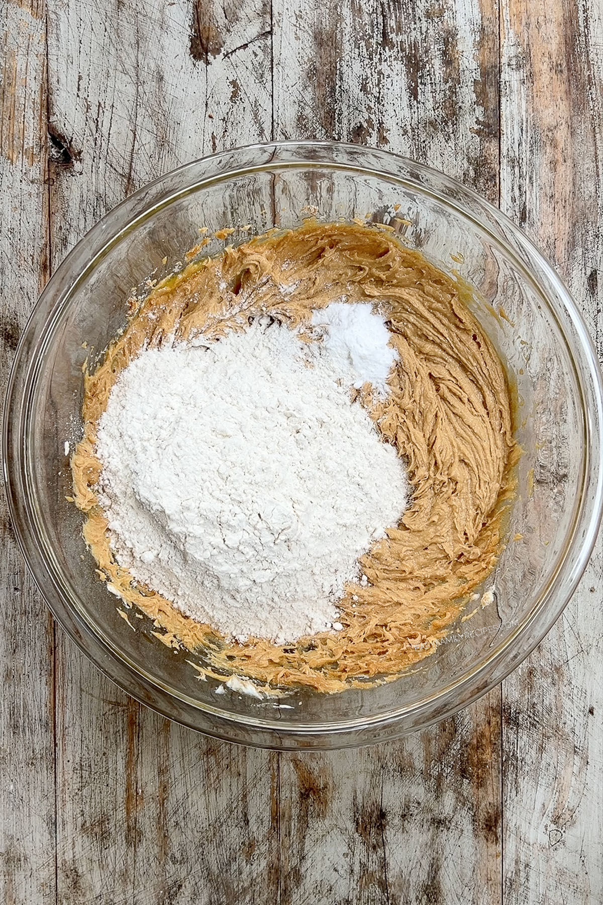 The dry ingredients are added to a glass bowl, creating the dough for Peanut Butter & Jelly Cookies.