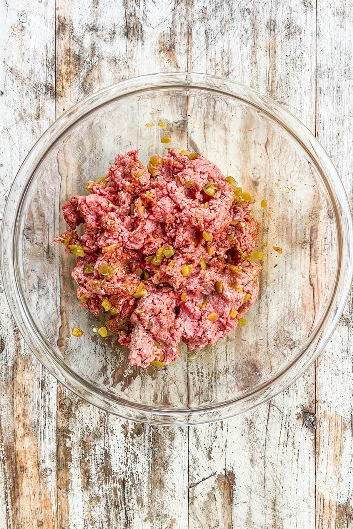 Ground beef and seasonings in a bowl after mixing.