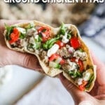 Hands holding a stuffed Mediterranean ground chicken pita.