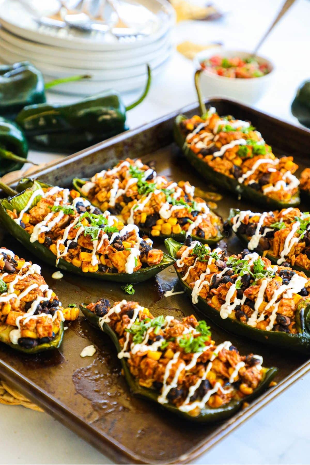 8 stuffed poblano peppers on a baking sheet