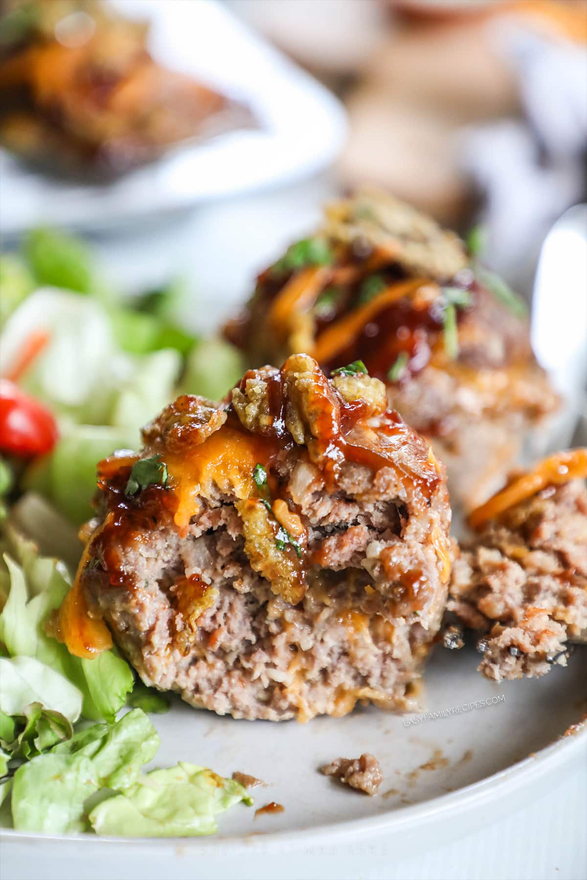 Close up of a bbq meatloaf muffin with a bite taken out to show inside texture.