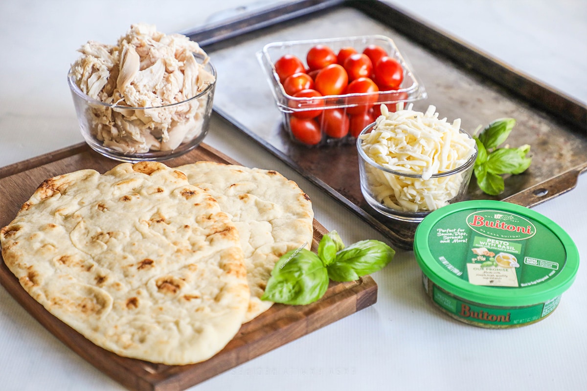 Ingredients for recipe: naan, shredded chicken, tomatoes, mozzarella, basil, and balsamic glaze.