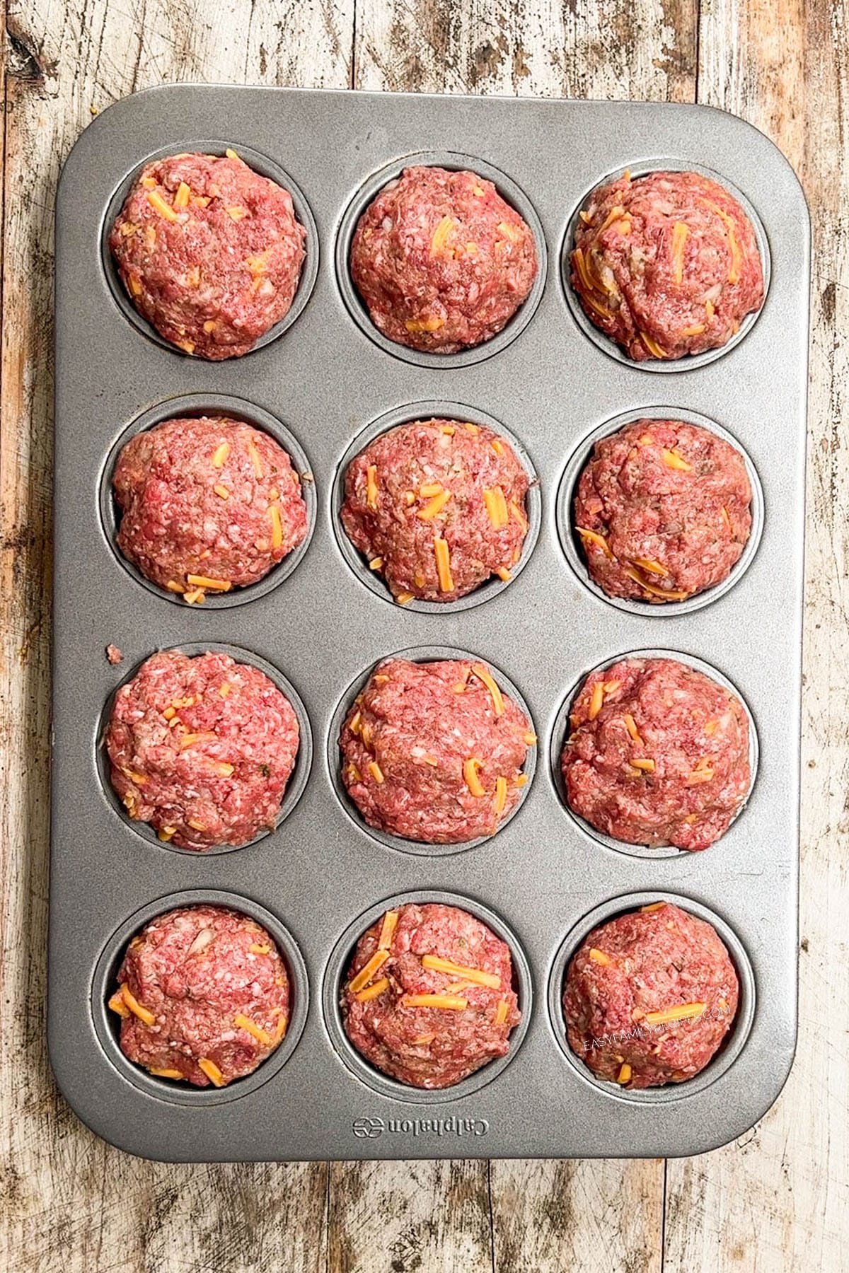 Meat mixture divided into a 12 tin muffin pan.