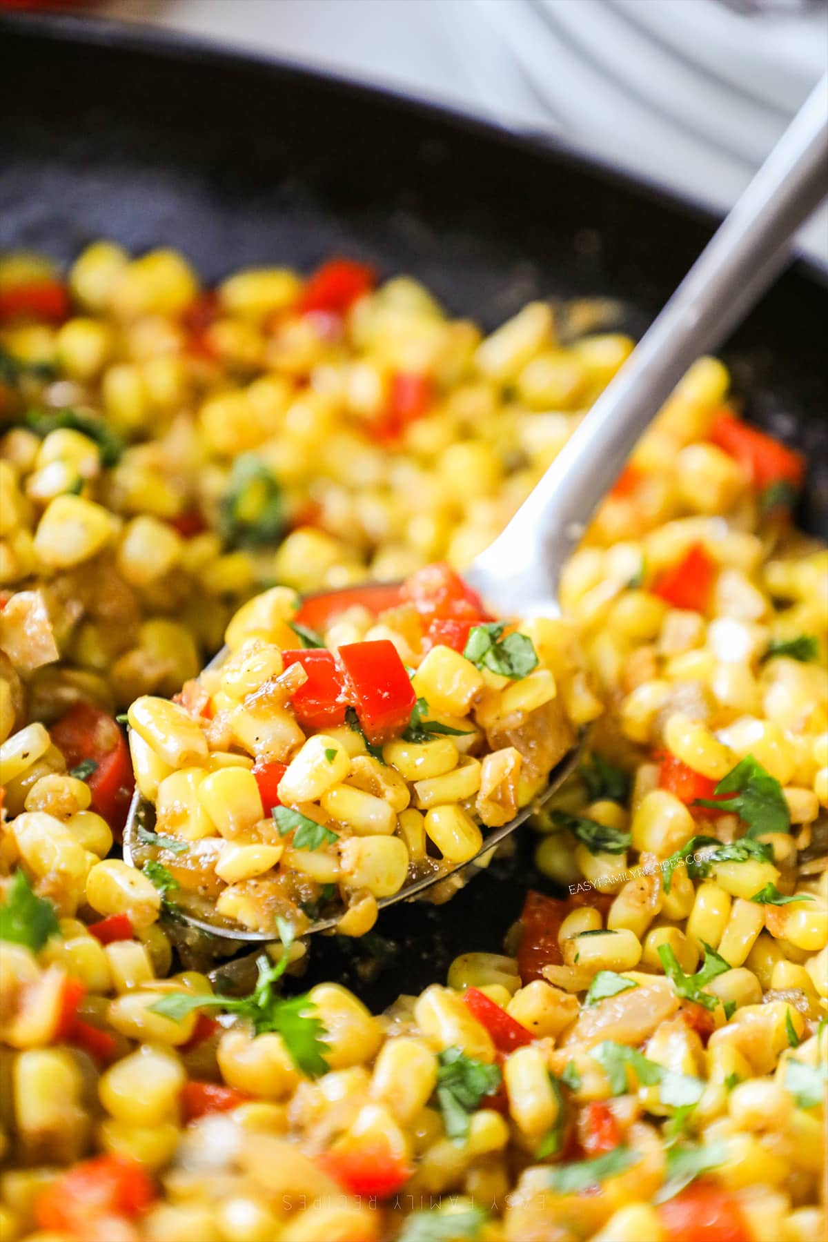 A spoon scoops out a serving of Southwest Corn. 