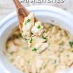 a wooden spoon holding a scoop of creamy garlic chicken bites over the slow cooker.