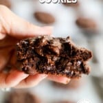 A hand holding a Devil's Food Cookie folded in half, showing the melty chocolate chips inside. The text reads, "Devils' Food Cookies."