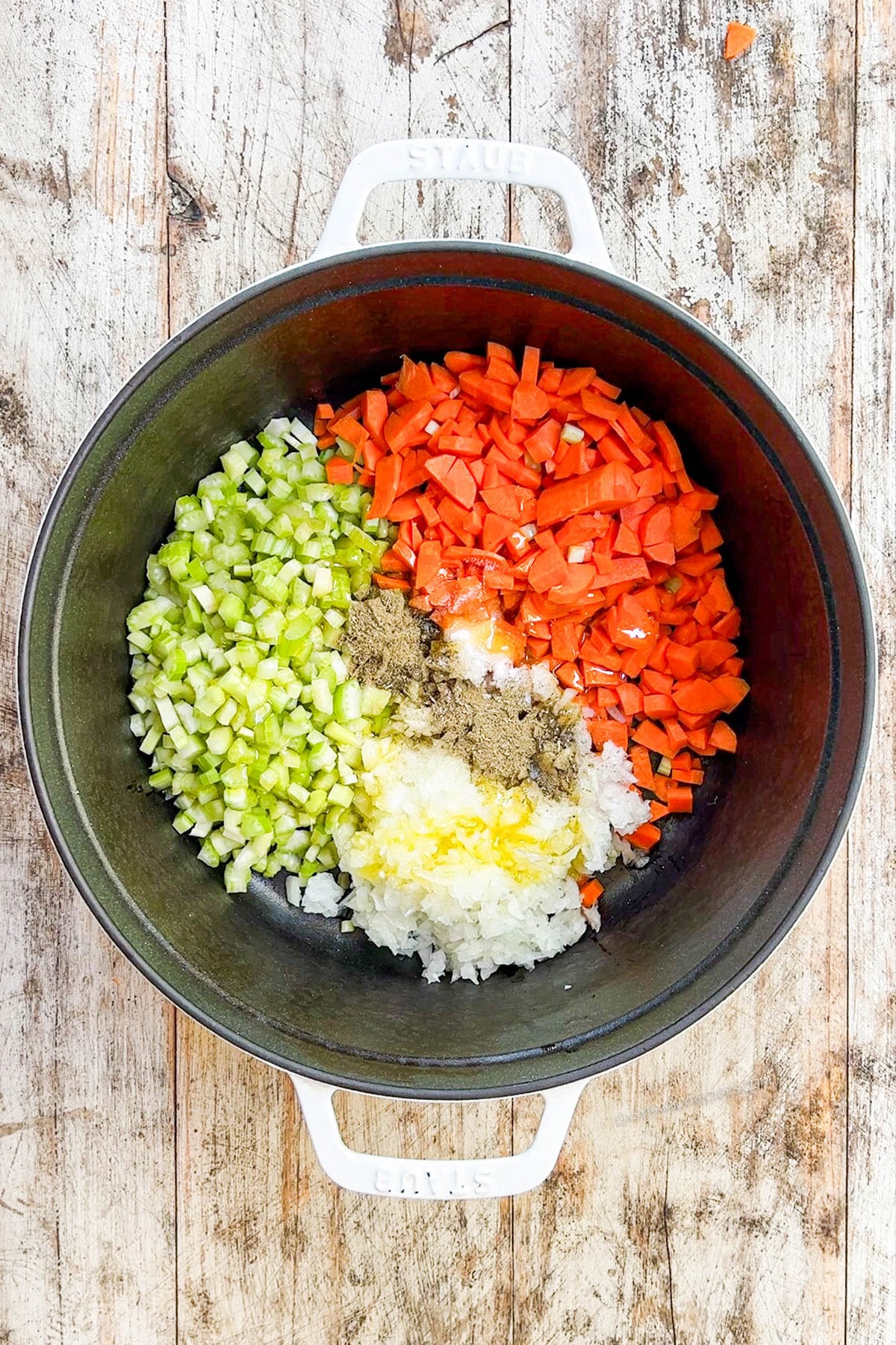 A black skillet full of veggies being sautéed for chicken noodle casserole.