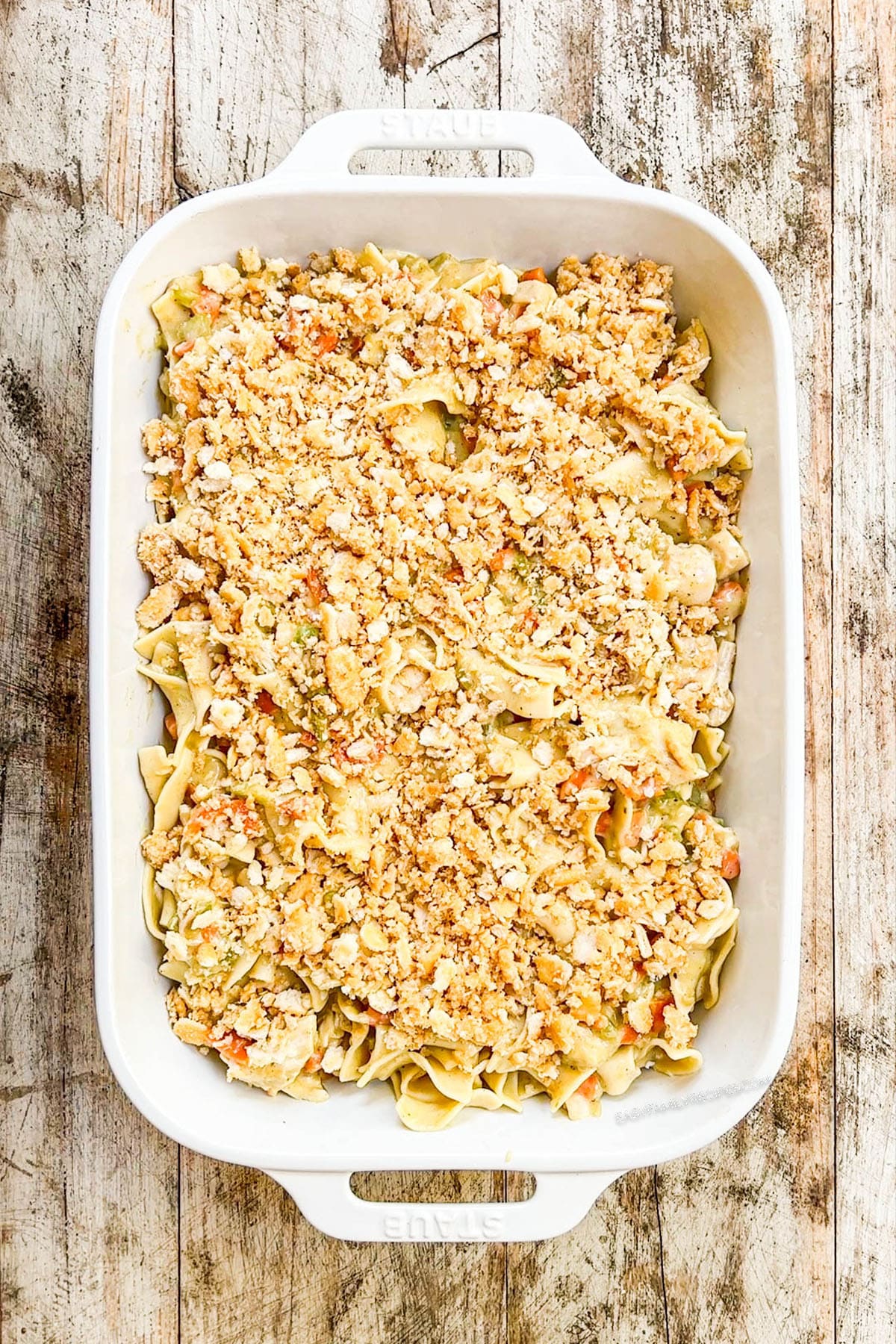 A top view of Chicken Noodle Casserole in a white baking dish ready to bake.