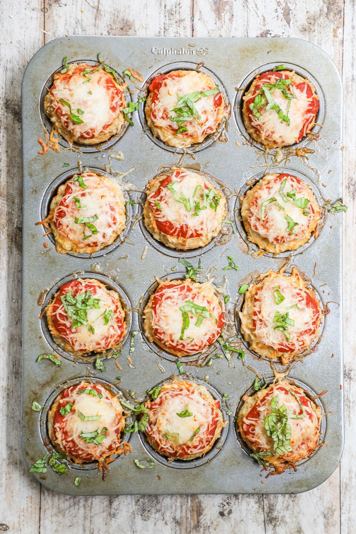 Baked Chicken Parmesan Meatloaf Muffins in a silver muffin tin.