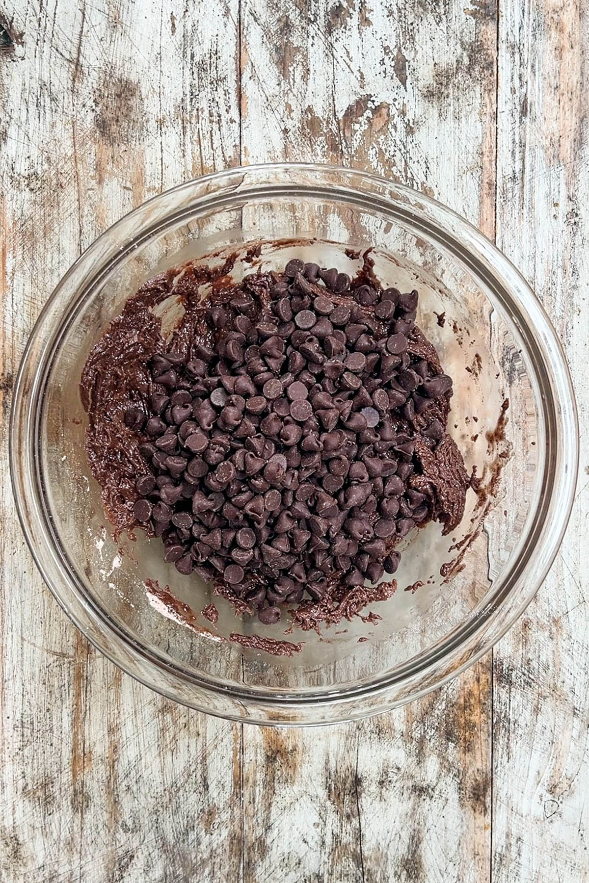 Chocolate chips are added to the batter of Devil's Food Cookies.