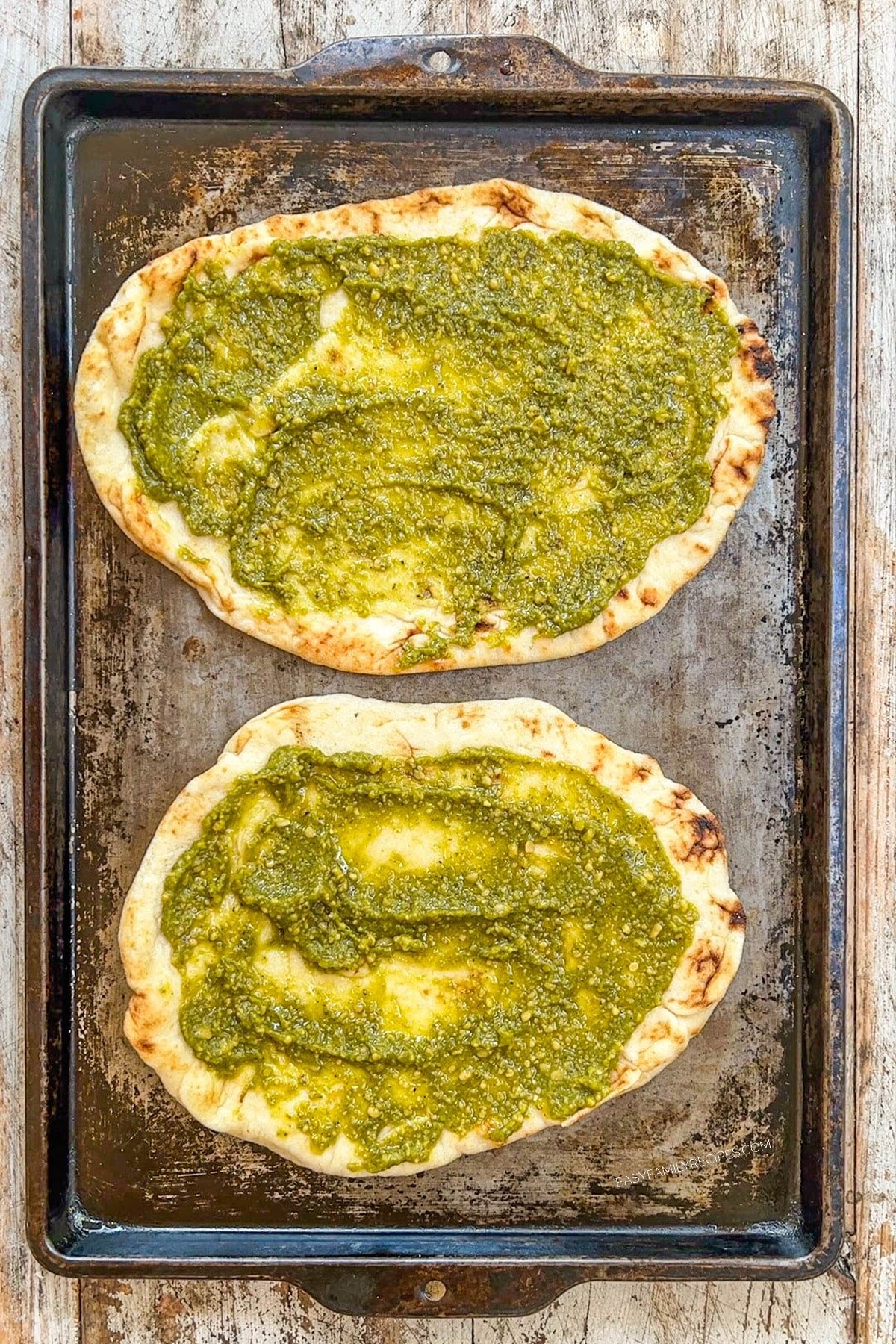 Pesto is smeared on naan for Mediterranean Flatbread pizzas.