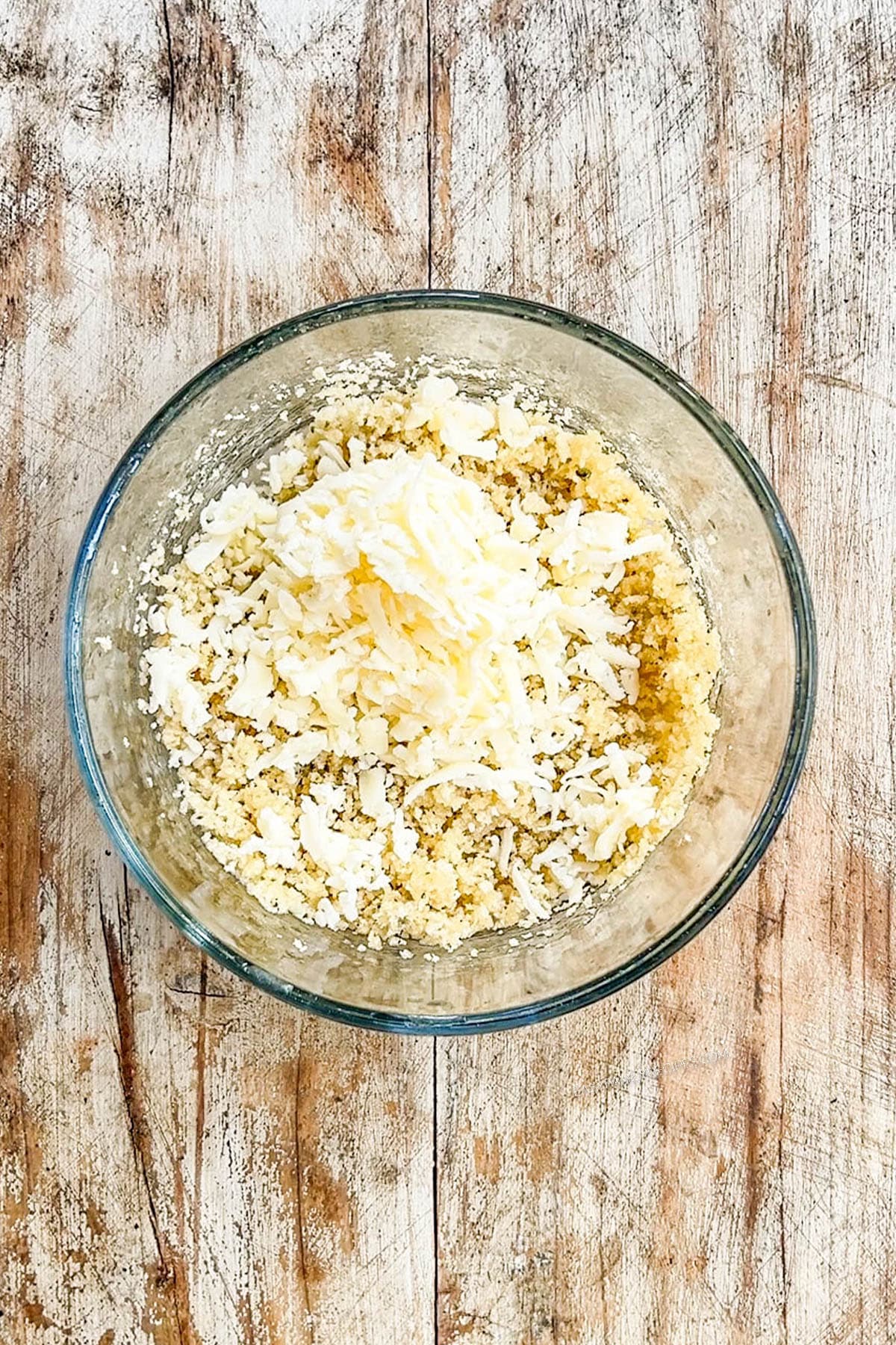 A glass bowl with the breadcrumb mixture for Monterey Jack Unfried Chicken.