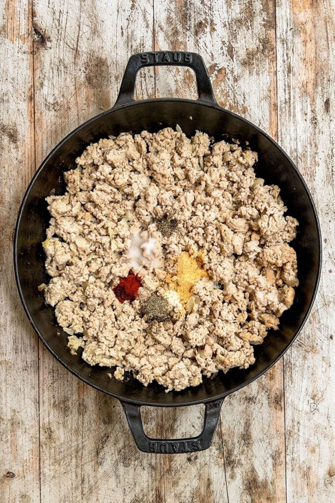 ground chicken in a skillet with spices. 