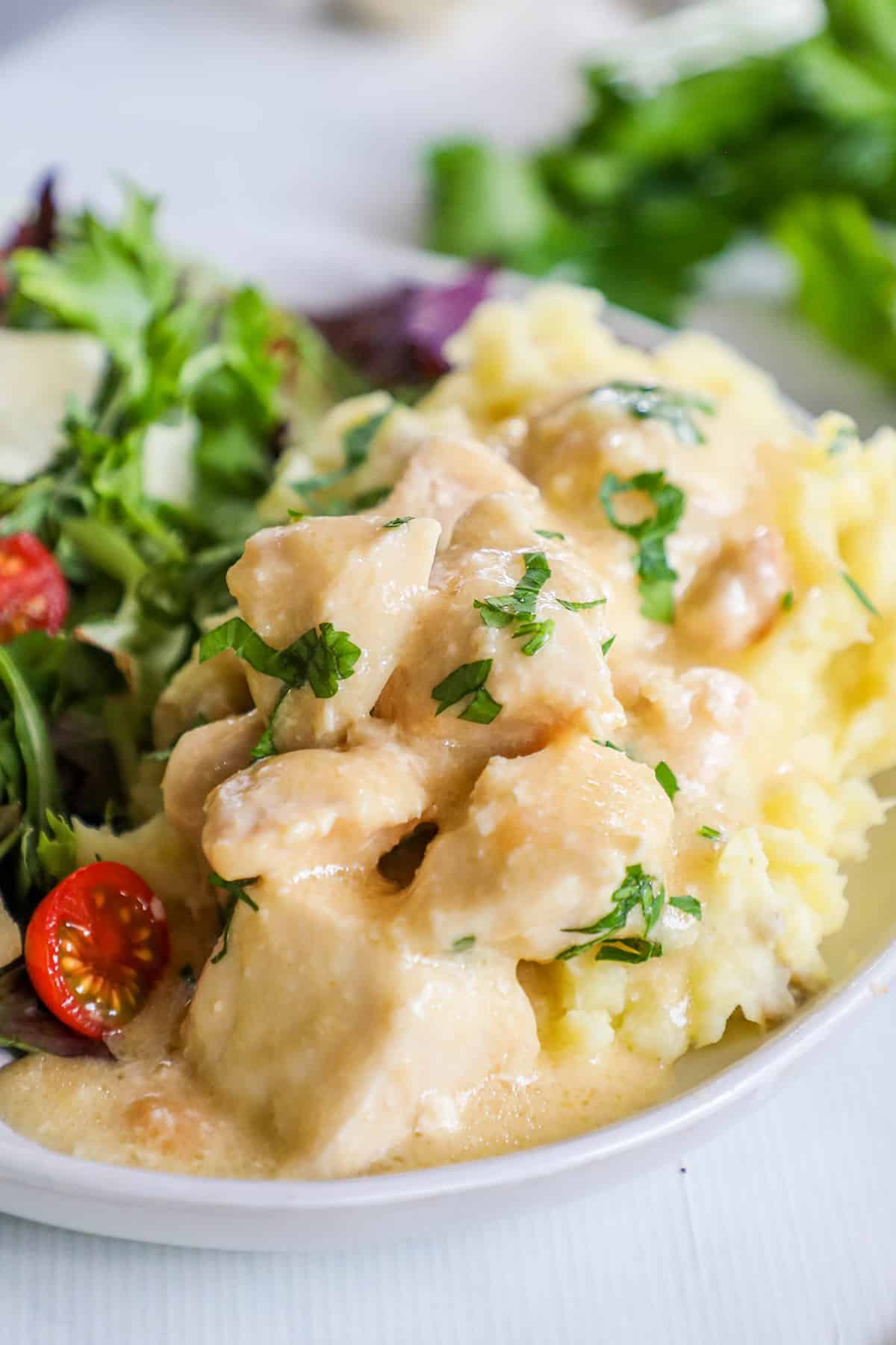 creamy garlic chicken on a plate served with a salad. 