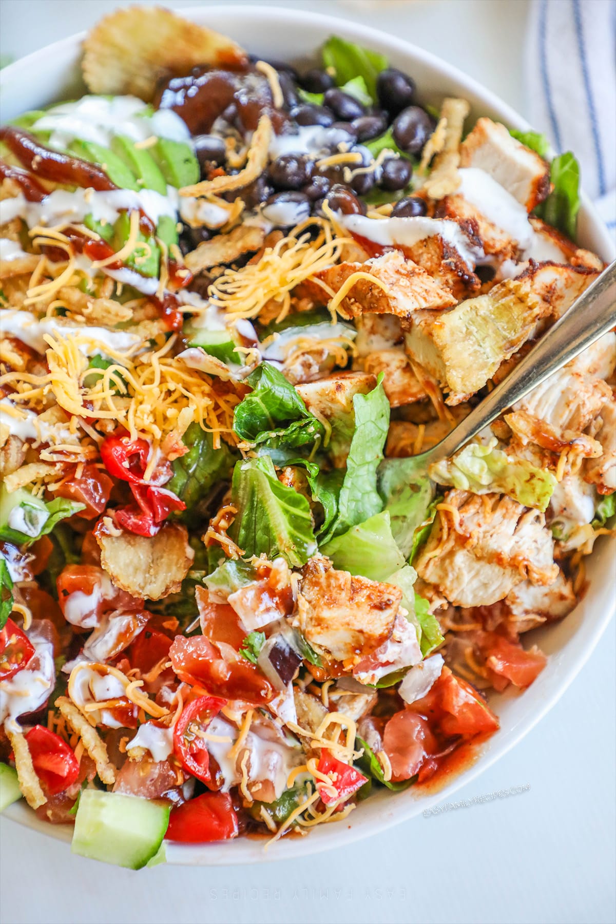 BBQ ranch chicken salad in a white bowl with a silver fork.