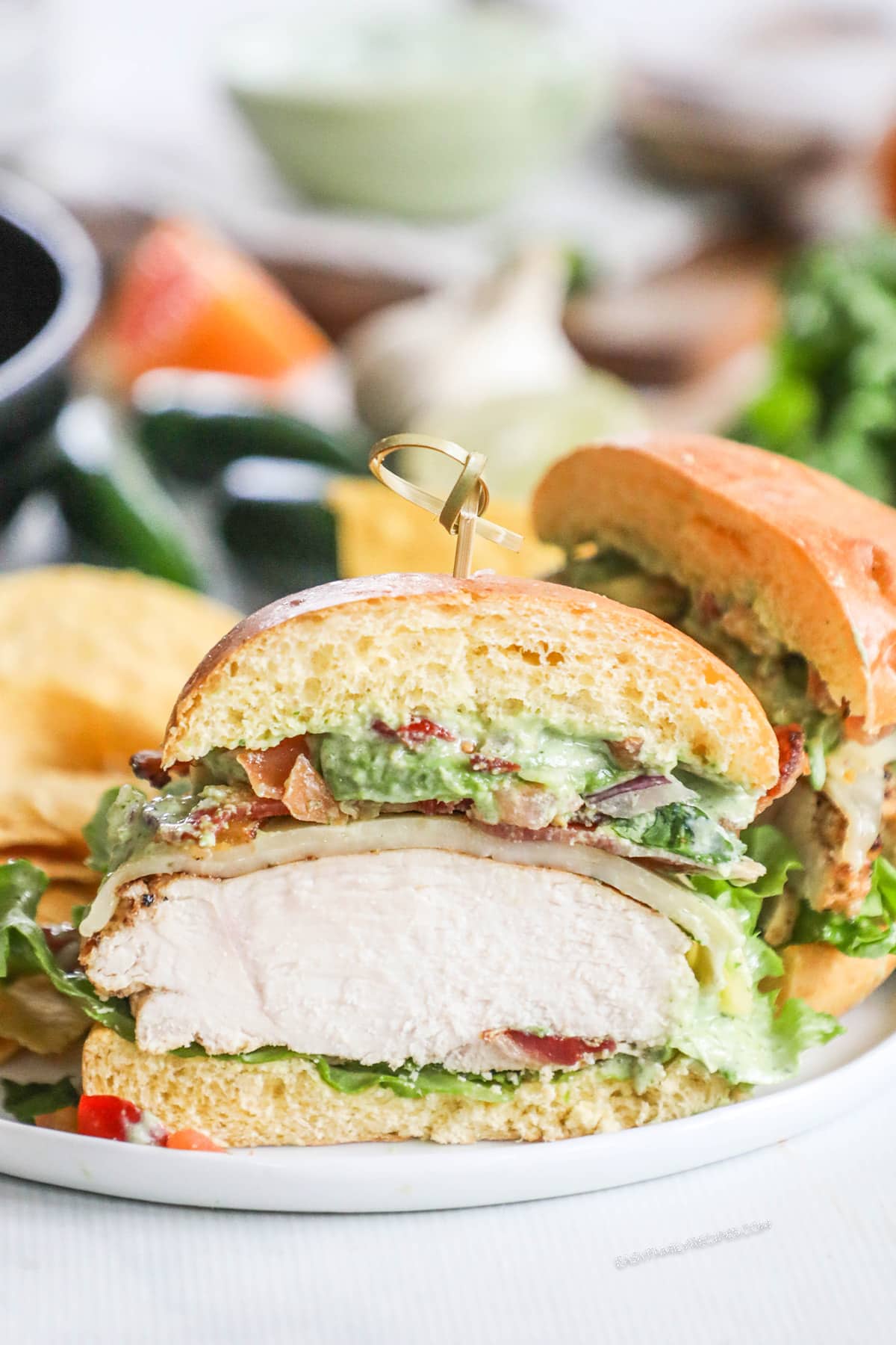 A Baja Chicken Sandwich, cut in half, on a white plate.