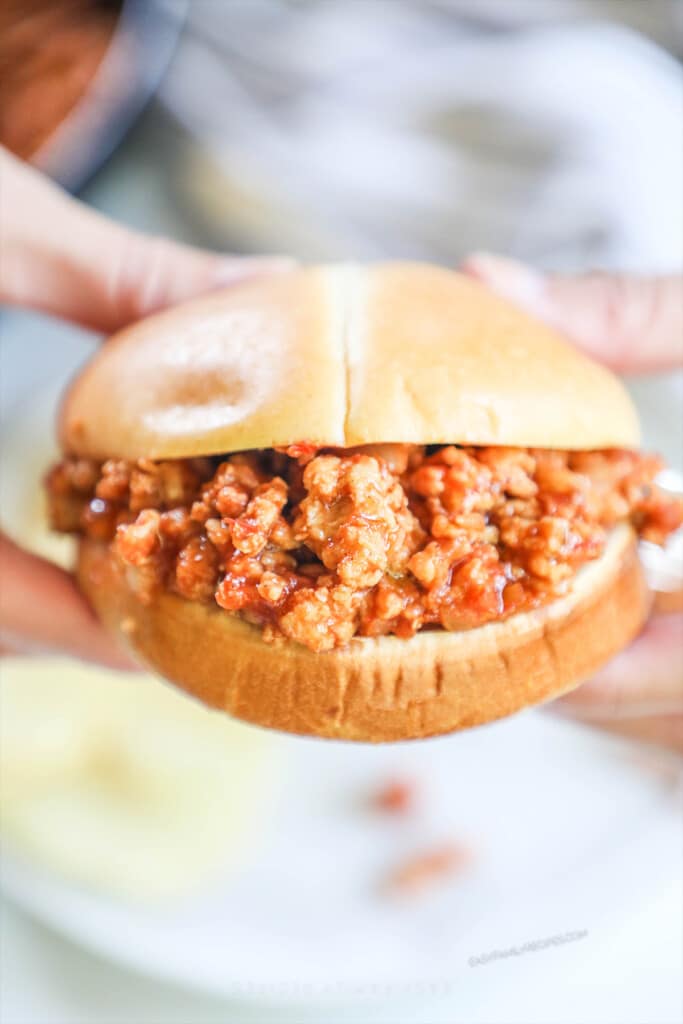 a chicken sloppy joe sandwich held.