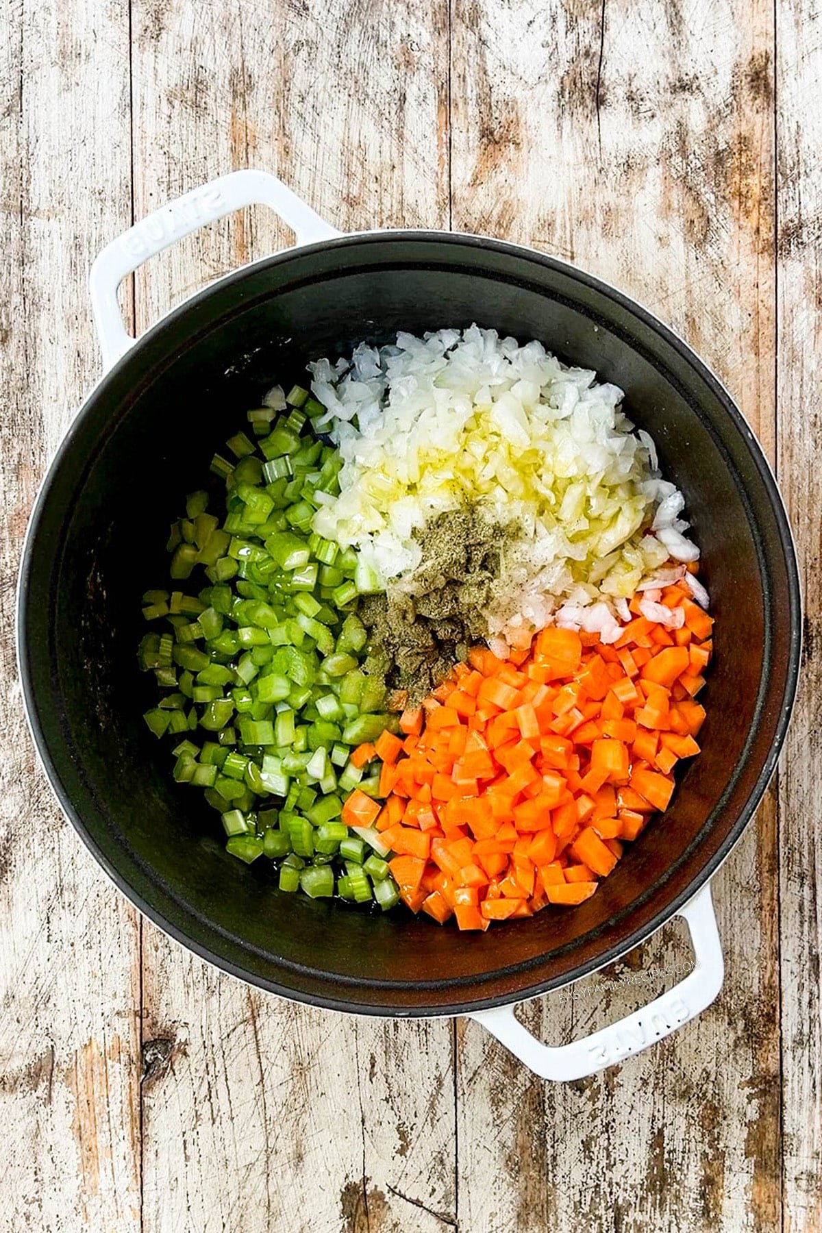 Vegetables and seasonings are added to a Dutch oven for Creamy Lemon Chicken Orzo Soup.