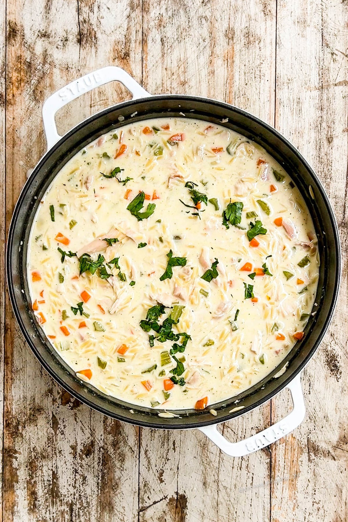 Creamy Lemon Chicken Orzo Soup in a white Dutch oven.