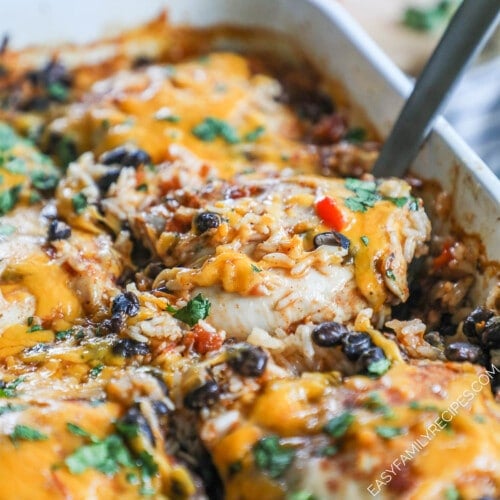 A spatula scoops out a cooked chicken thigh out of Mexican Chicken & Rice Bake.