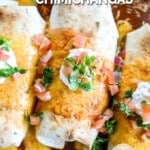 Baked Chicken Chimichangas on a baking sheet with sour cream, salsa, and cilantro, ready to serve. The text reads, “Baked Chicken Chimichangas.”