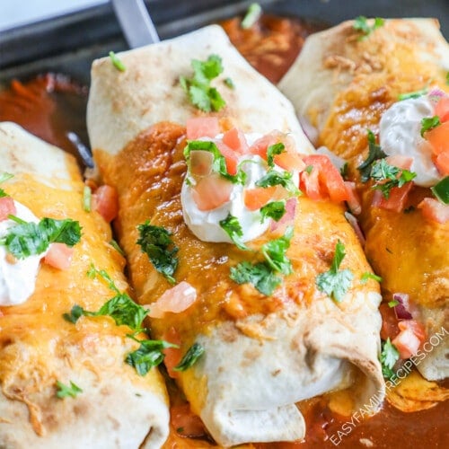 Baked chimichangas are topped with sour cream and cilantro.