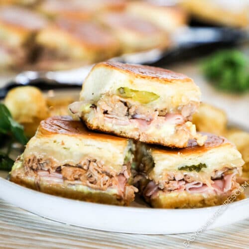 A white plate full of Hawaiian Roll Cuban Slider sandwiches.