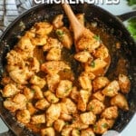 Garlic Butter Chicken Bites in a black skillet with a wooden spoon in it. The text reads, “Garlic Parmesan Chicken Bites.”