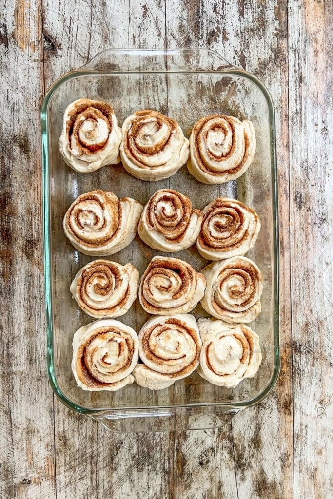 unbaked cinnamon rolls in a baking dish.