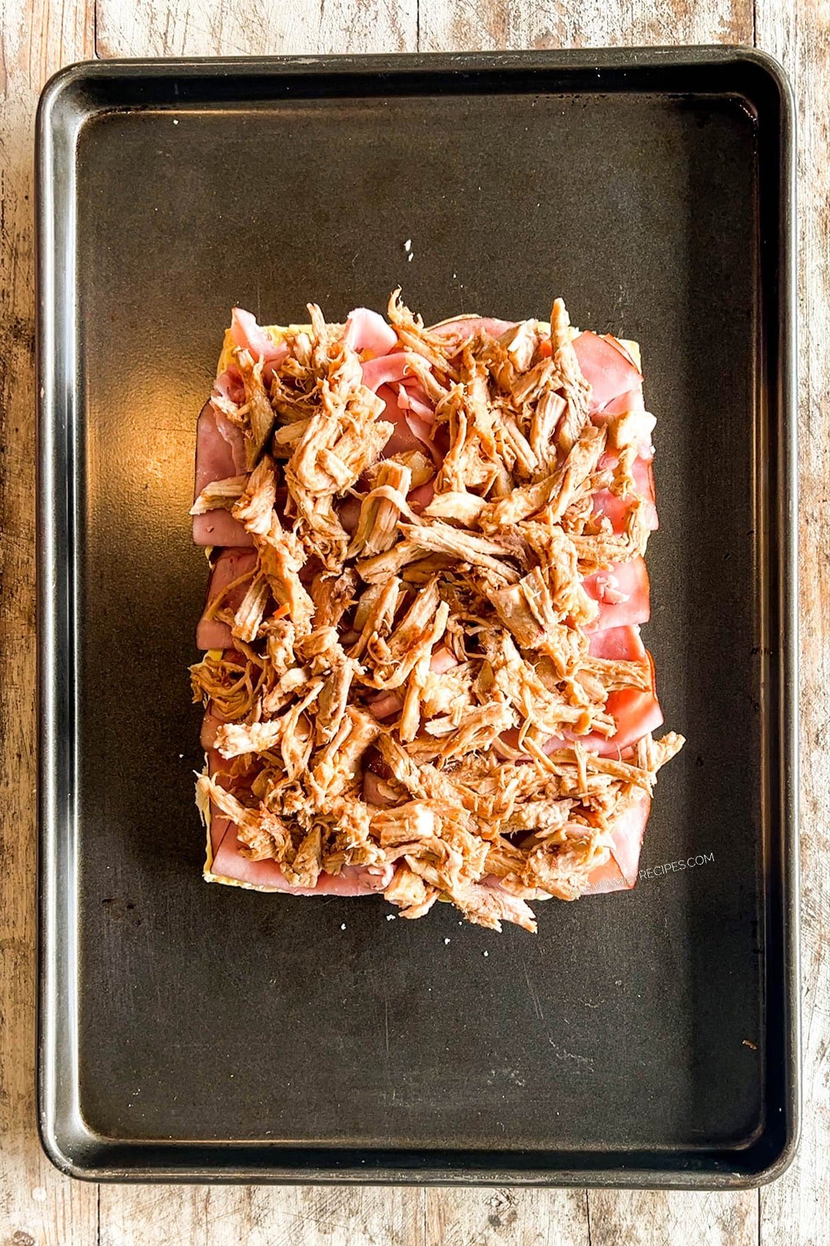 Pulled pork is placed on top of the ham for Hawaiian Roll Cuban Sliders.