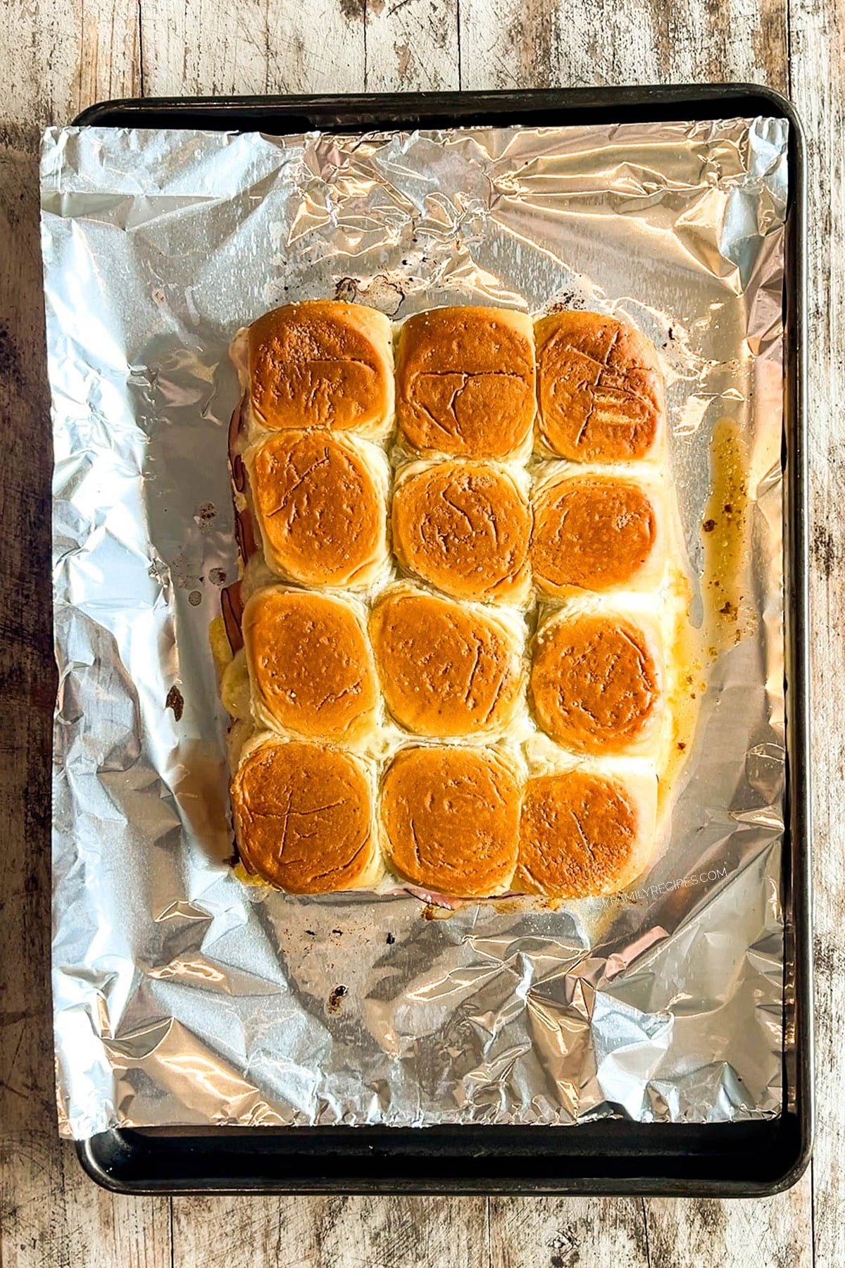 Hawaiian Roll Cuban Sliders on a sheet of foil, baked and ready to serve.