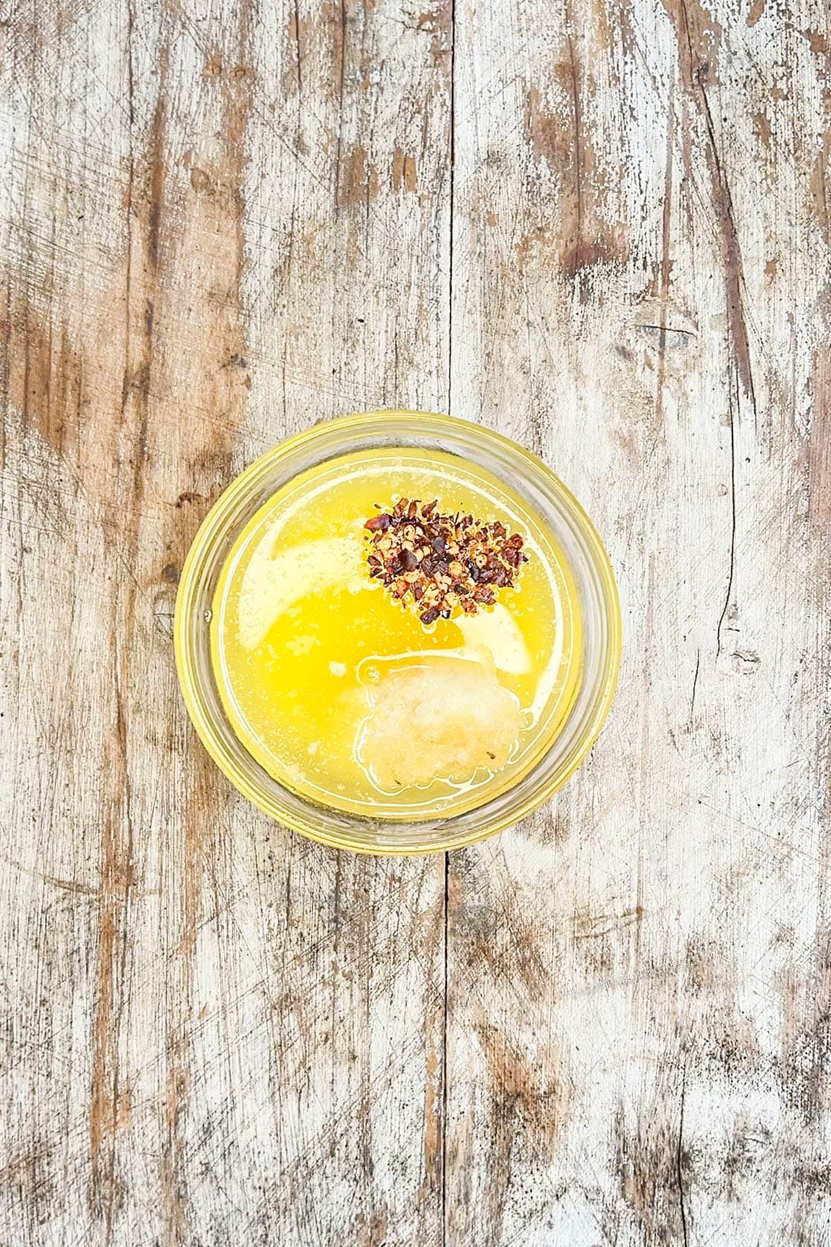 Melted butter in a glass bowl for garlic butter chicken bites.