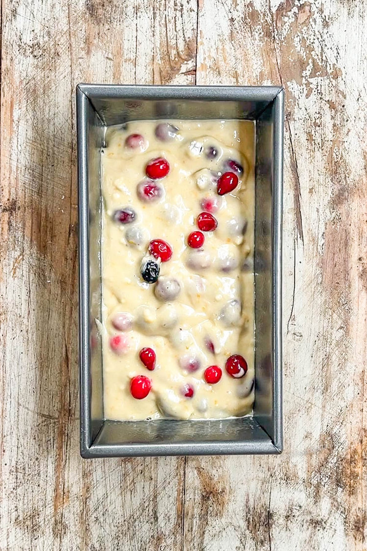 orange cranberry bread batter in a loaf pan, unbaked.