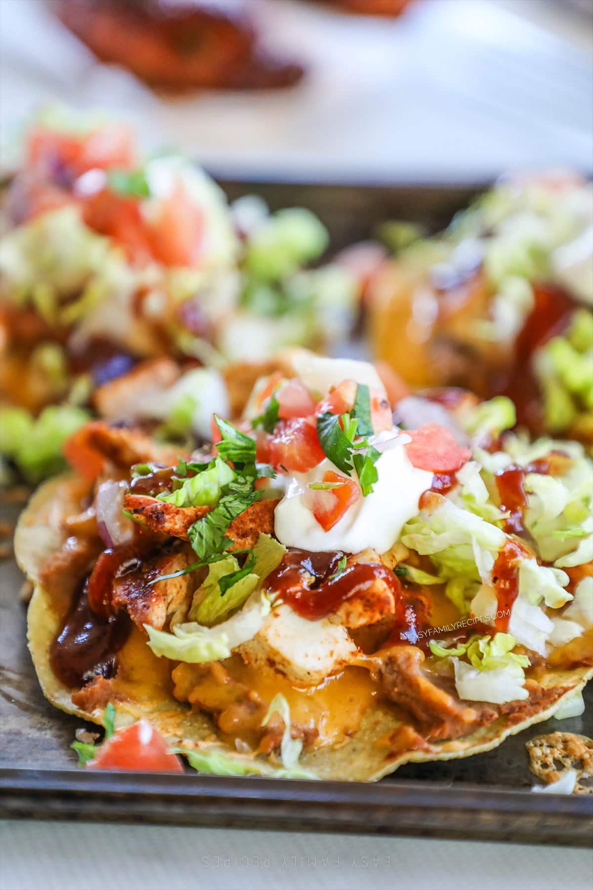 A close-up of a BBQ chicken tostada on a sheet pan.