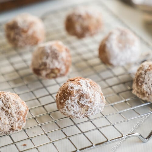 Cinnamon snowball cookies on a silver wire rack.